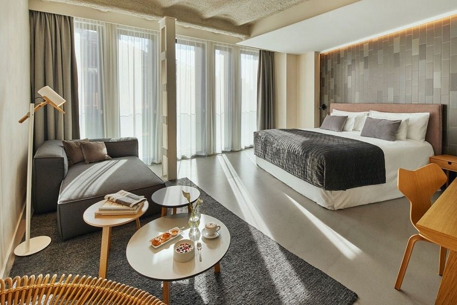 Modern, elegant Superior Room at Ohla Eixample hotel with minimalist white decor, sleek furnishings, and contemporary design featuring floor-to-ceiling windows