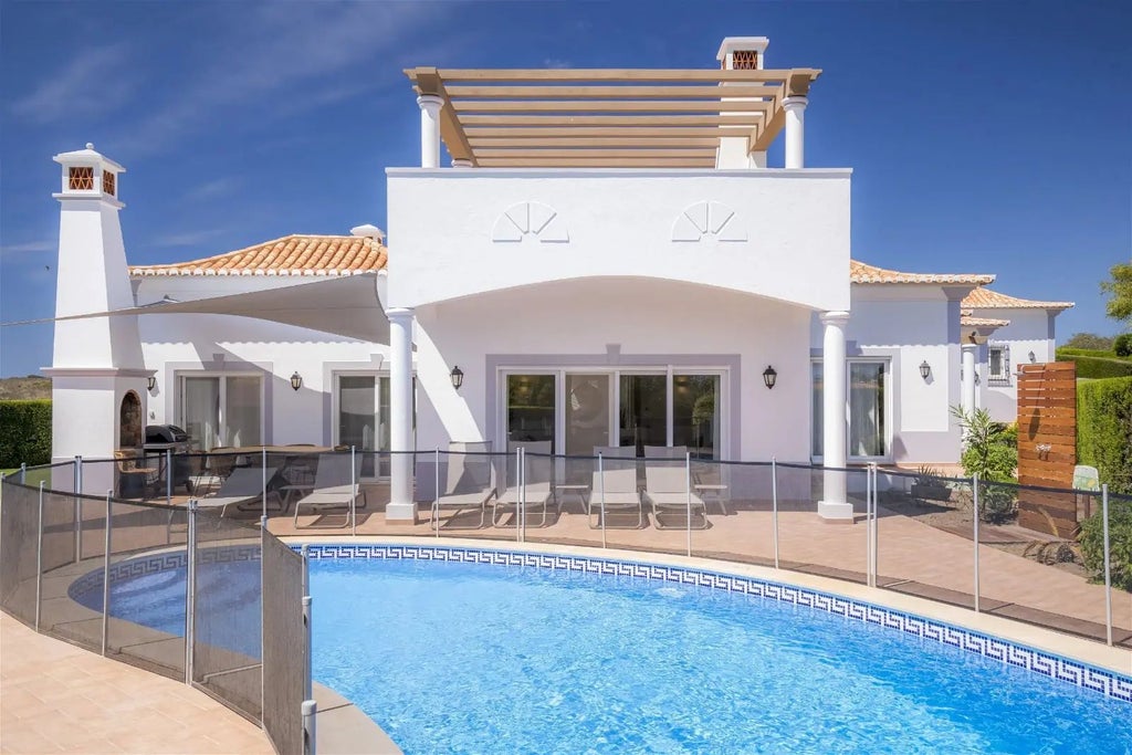 Luxurious white and blue villa at Martinhal Sagres Beach Resort, featuring modern design, panoramic windows, and serene coastal landscape backdrop in Portugal