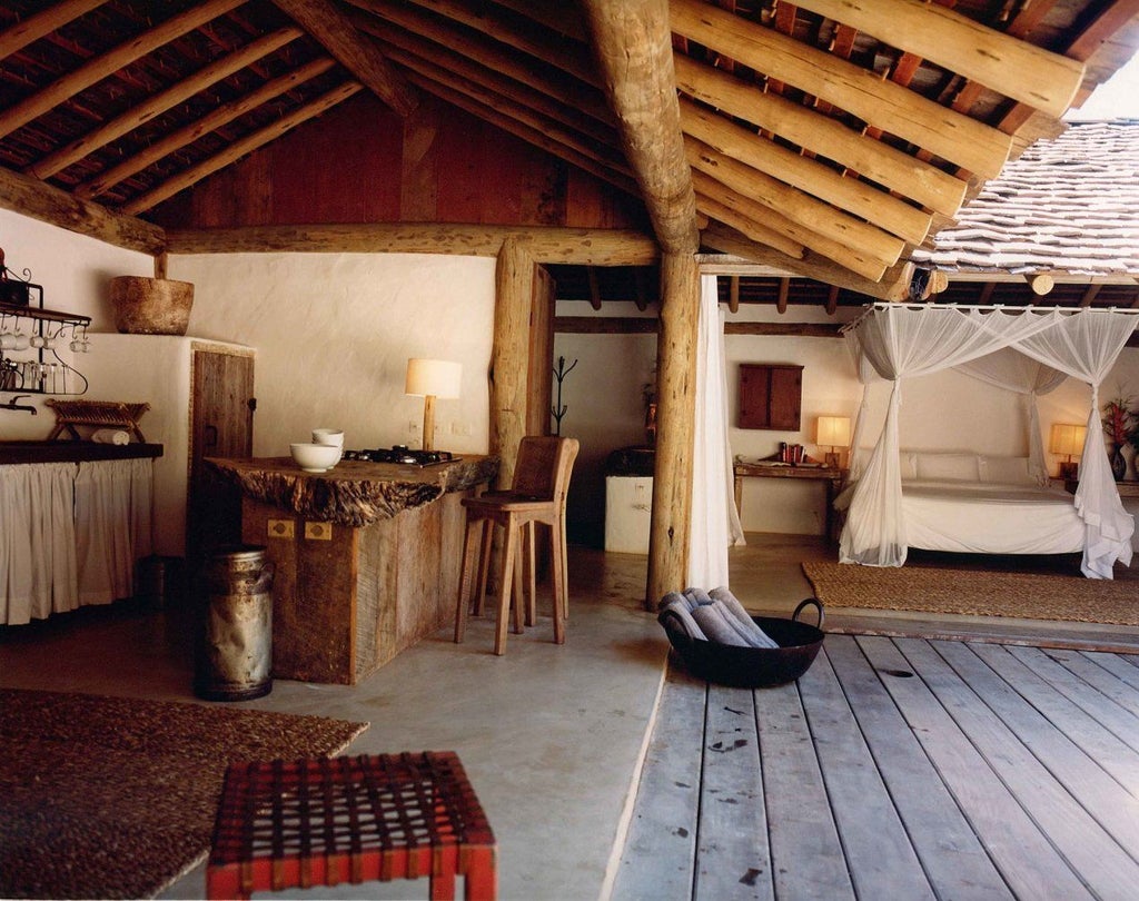 Rustic wooden interior of a luxurious Brazilian hotel room with traditional design, warm lighting, and handcrafted furniture at UXUA Casa Hotel and Spa