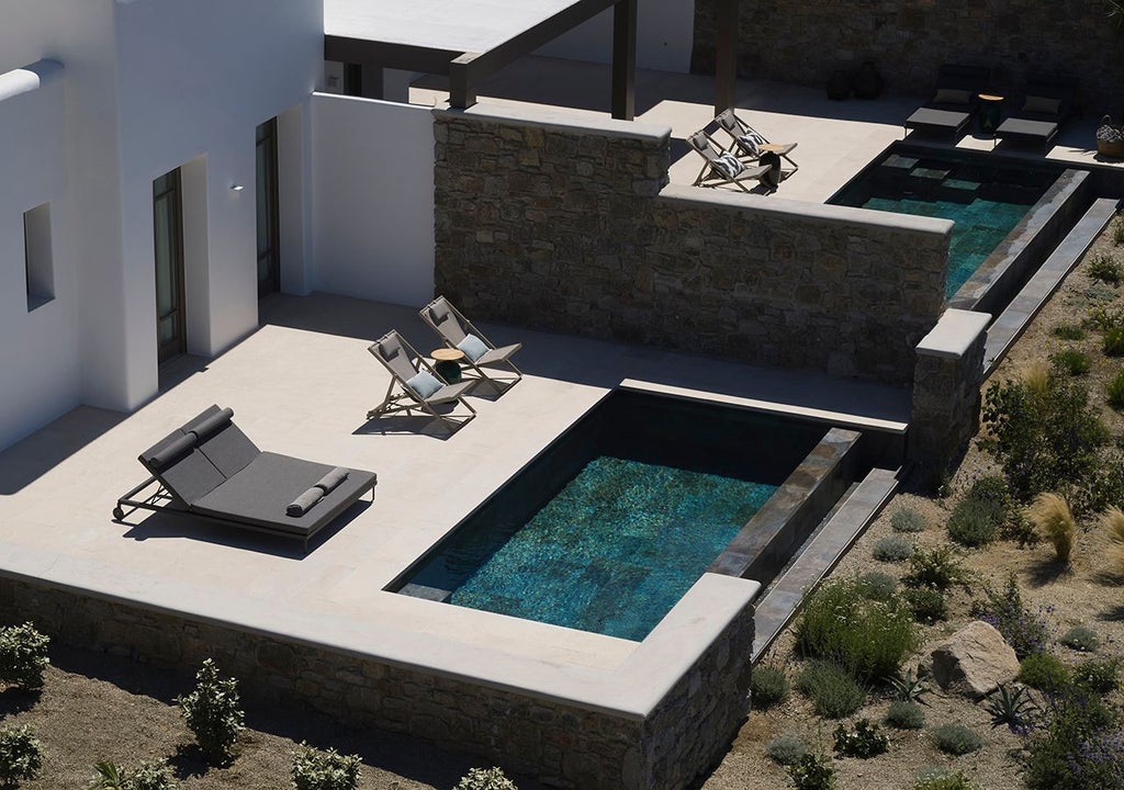 Luxurious one-bedroom suite in Mykonos with panoramic Aegean Sea view, private heated pool, and elegant modern Greek island design