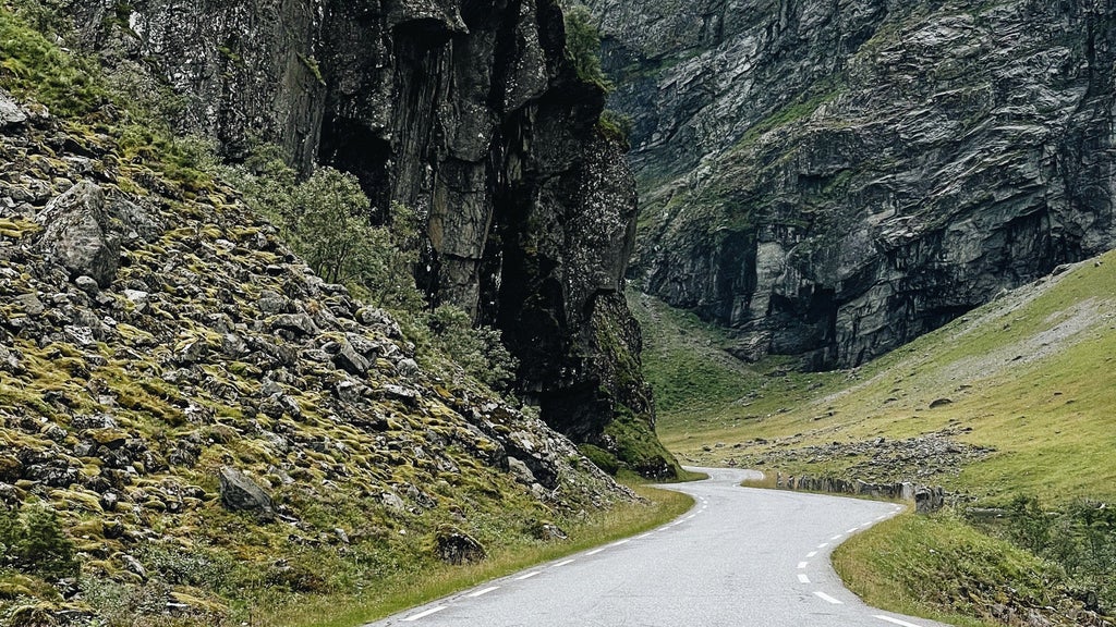 Scenic mountain biking trail through lush Norang Valley in Norway, cyclists enjoying breathtaking fjord landscapes with verdant greenery and pristine wilderness