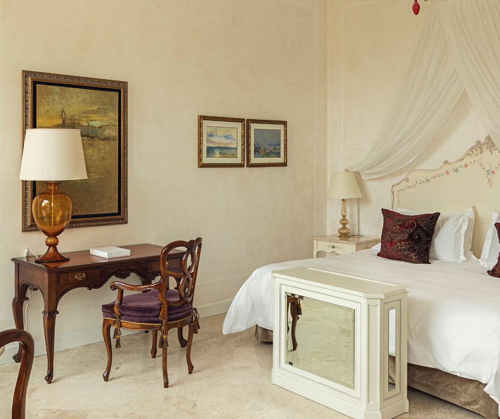 Elegant suite with pool-view terrace featuring plush king bed, marble bathroom, and classic Venetian decor in soft cream and gold tones