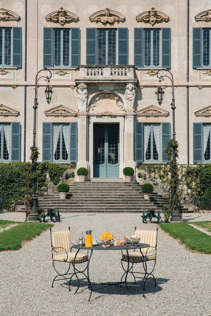 Luxury Italian lakeside hotel with Art Nouveau facade, featuring a floating pool on Lake Como and manicured gardens against mountain backdrop