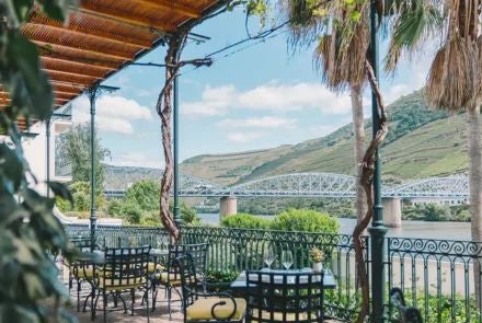 Historic Portuguese luxury boutique hotel with elegant stone facade, warm golden lighting, and traditional architectural details nestled in a charming cobblestone street at dusk.