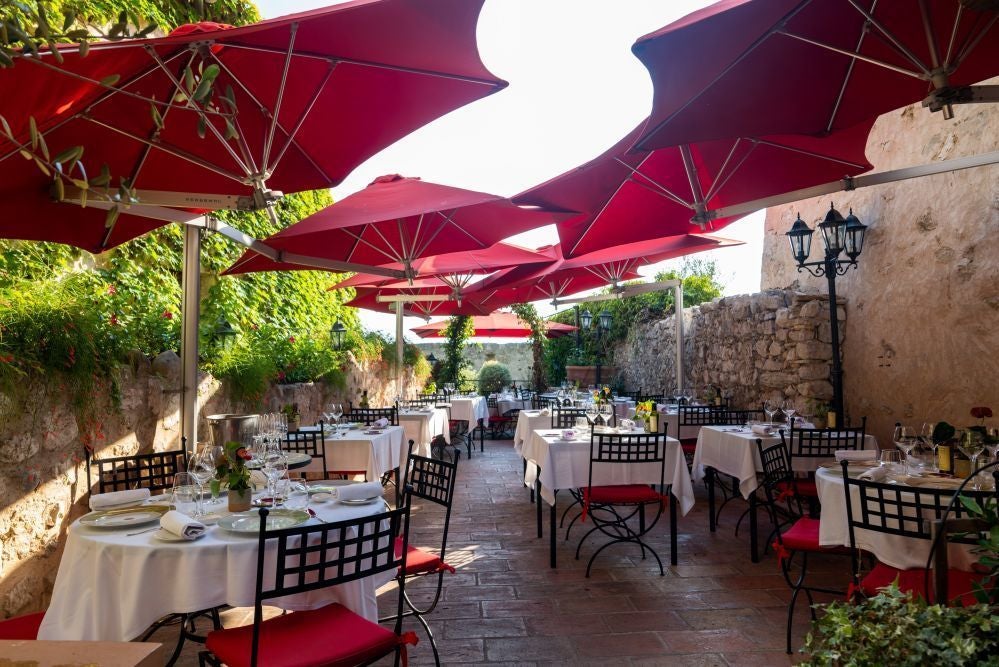 Elegant limestone facade of Hotel Le Saint in scenic French countryside, featuring traditional architectural details and pristine landscaped gardens at golden hour