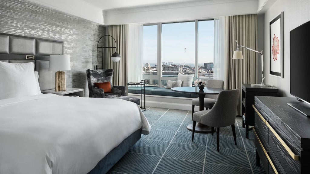 Luxurious Four Seasons hotel room in San Francisco with panoramic city skyline view, modern decor, plush king bed, and floor-to-ceiling windows