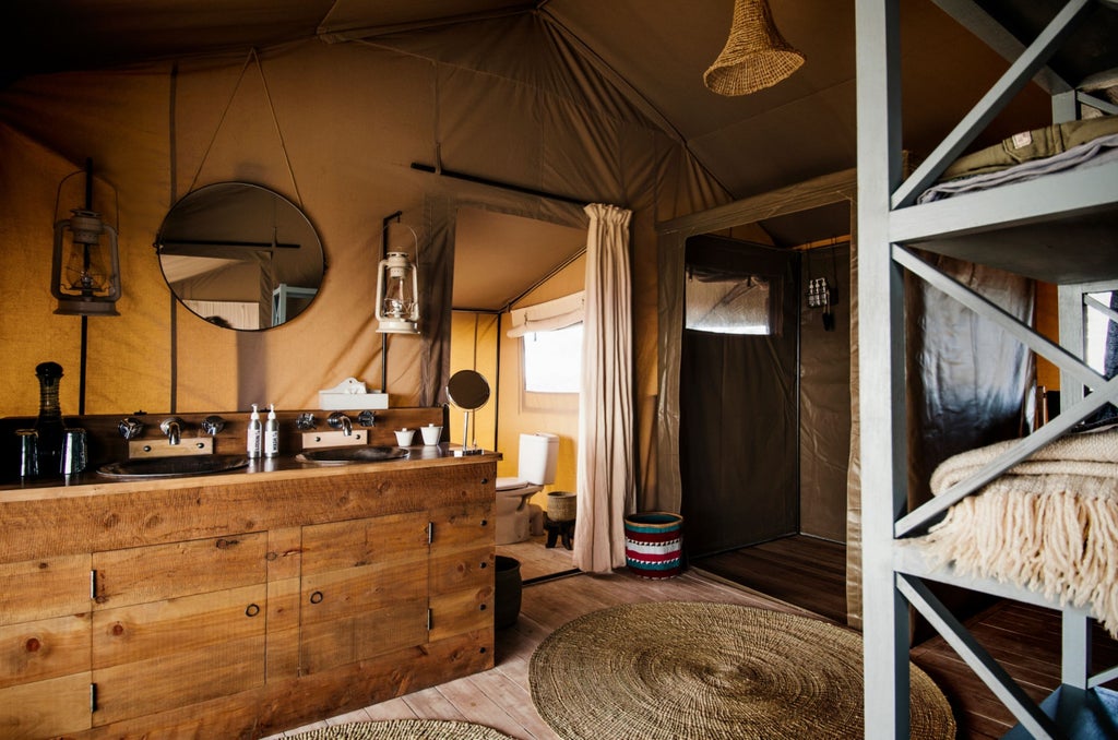 Luxury safari tent perched on Ngorongoro Crater rim with canvas walls, wooden deck, and panoramic views of African savanna