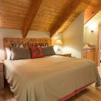 Rustic two-bedroom cabin at Scenset Mountain Ranch with warm wood interiors, plush furnishings, and panoramic wilderness views of scenic mountain landscape