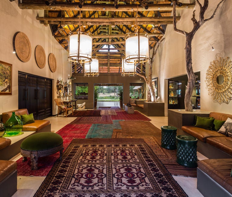 Luxurious safari lodge nestled in African bush with private plunge pool, thatched roof, and wooden viewing deck overlooking wilderness