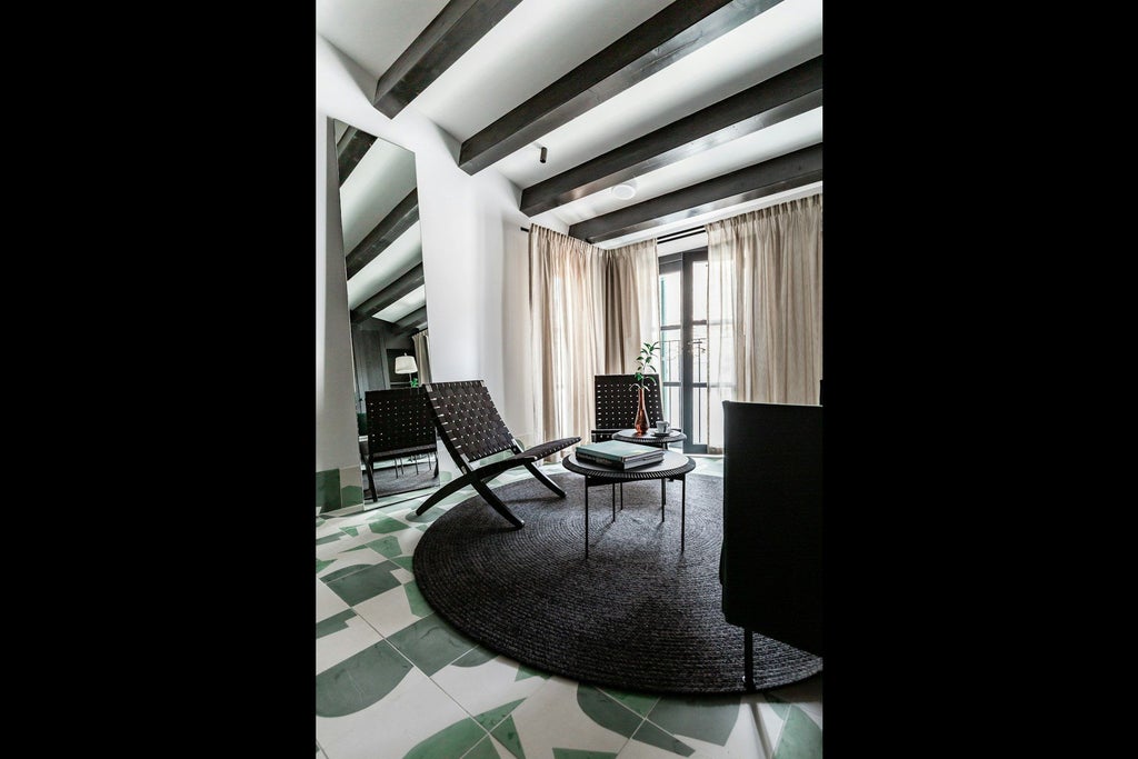 Elegant minimalist junior suite in warm neutral tones, featuring sleek modern furniture and large windows with soft natural lighting in Spain's design hotel