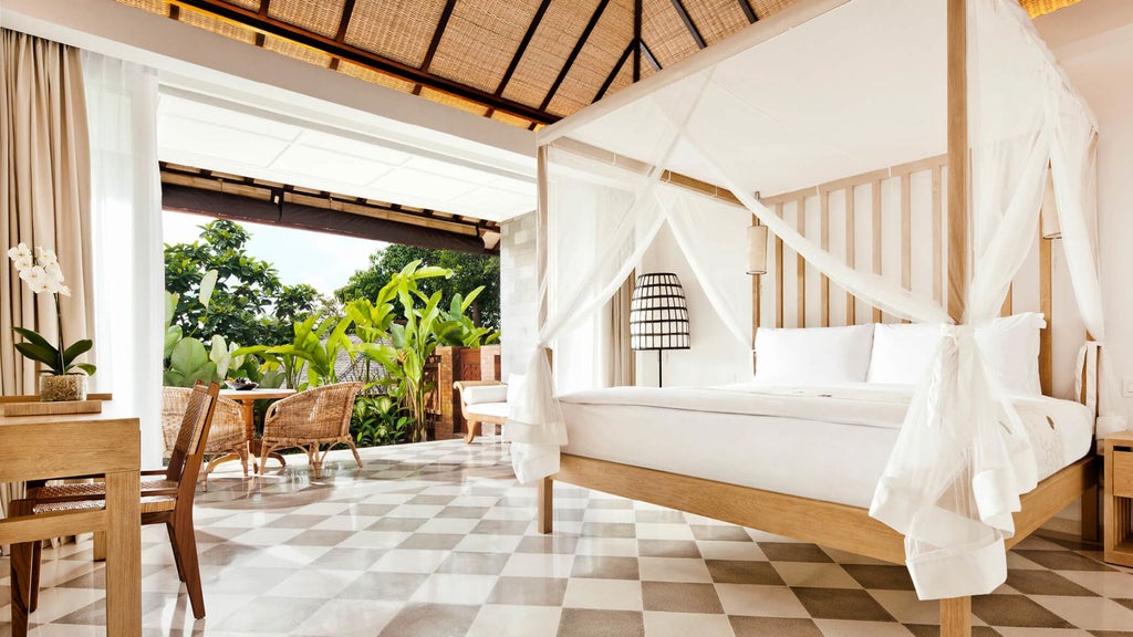 Contemporary hotel room with terrace overlooking lush Balinese jungle, featuring elegant wood furnishings and floor-to-ceiling windows