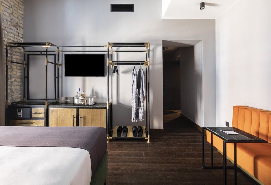 Elegant modern hotel interior with soft neutral tones, minimalist design, cozy lounge area with plush seating and warm ambient lighting in Rome, Italy