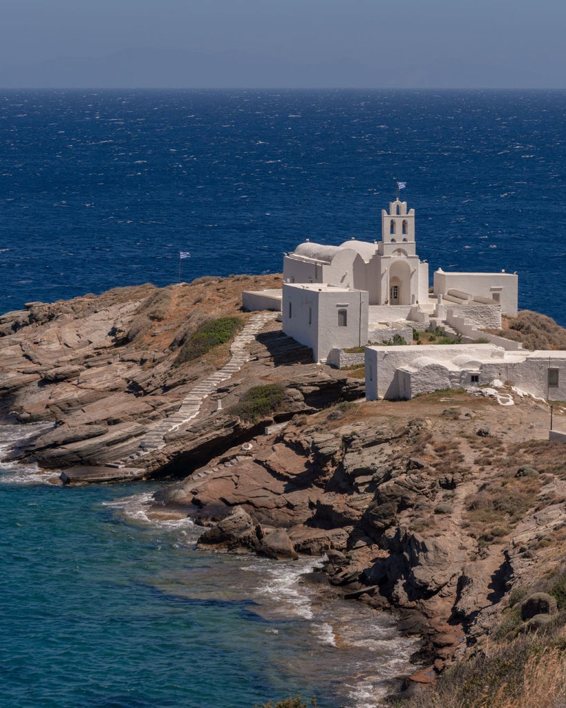 Elegant white Mediterranean villa with infinity pool overlooking the Aegean Sea, featuring traditional Greek architecture and sunlit terraces