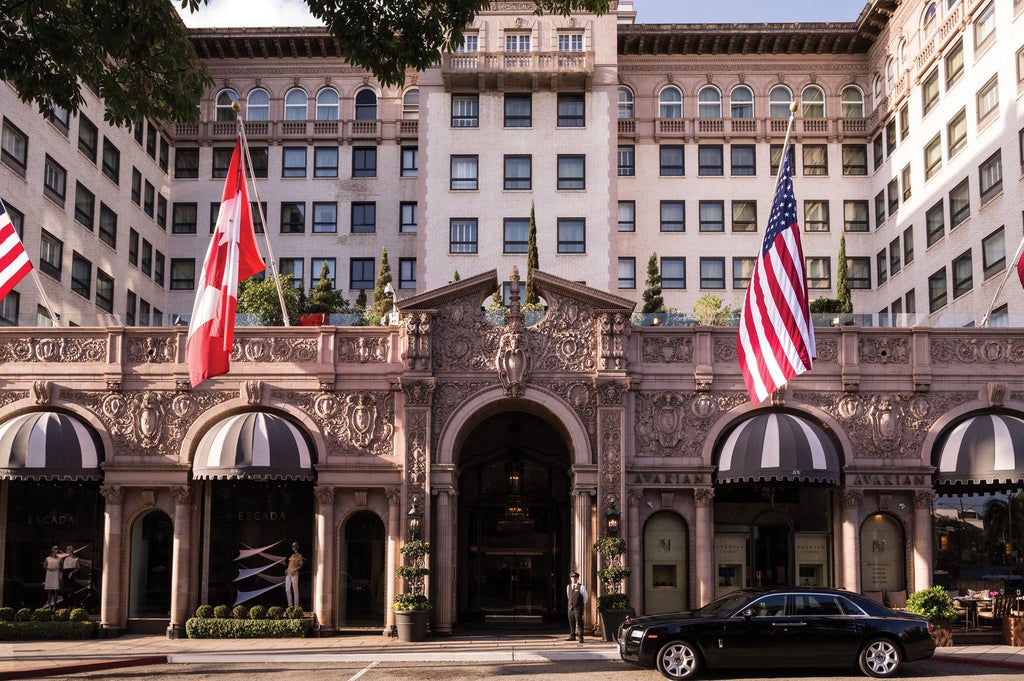 Iconic Four Seasons Beverly Wilshire's grand facade with Mediterranean-style architecture, ornate balconies, and manicured palm trees.