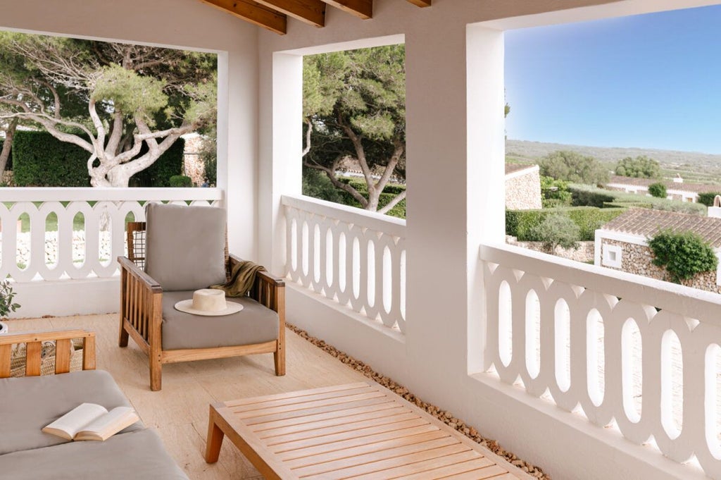 Spacious luxury hotel room with panoramic Mediterranean sea view, elegant white decor, minimalist design, and large windows overlooking scenic Spanish coastline at Torralbenc