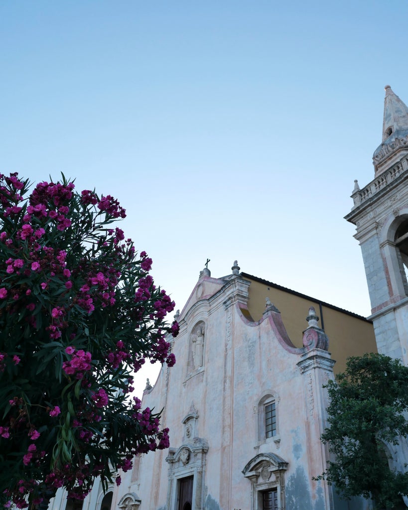 Elegant cliffside town of Taormina, Sicily, with historic architecture and stunning Mediterranean Sea views at golden hour