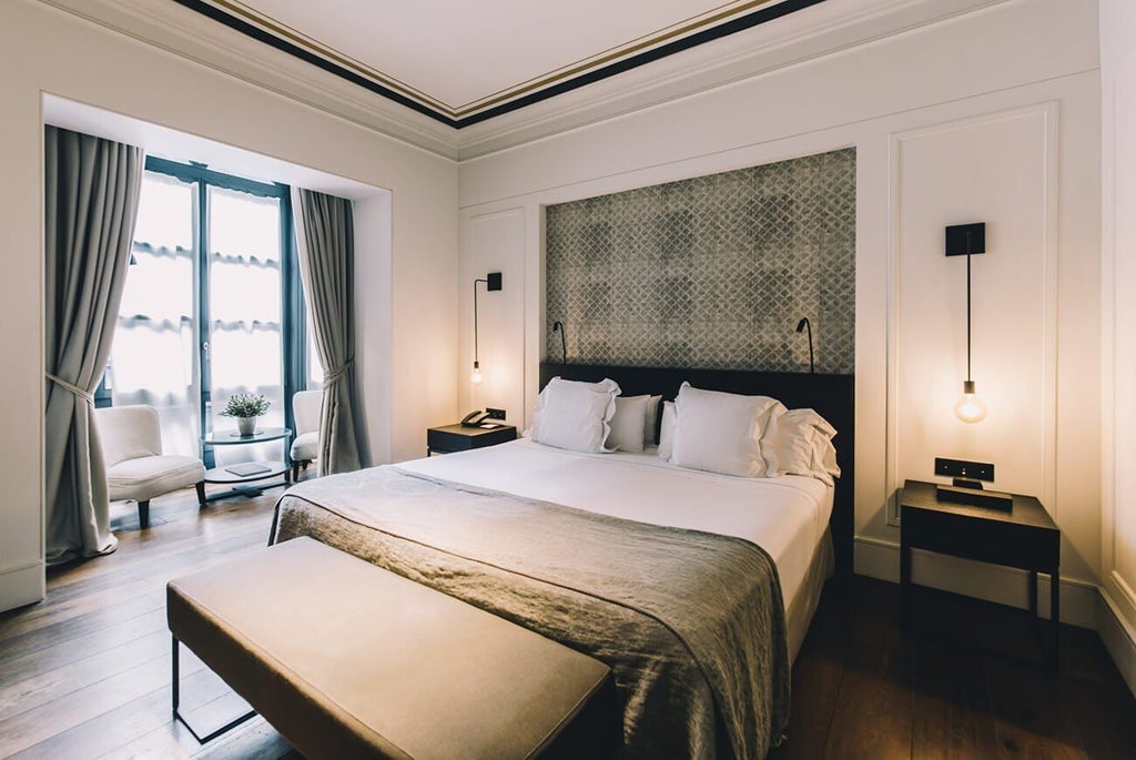 Elegant deluxe hotel room with modern minimalist design, white marble details, and sleek contemporary furnishings at Sant Francesc Hotel Singular in Spain