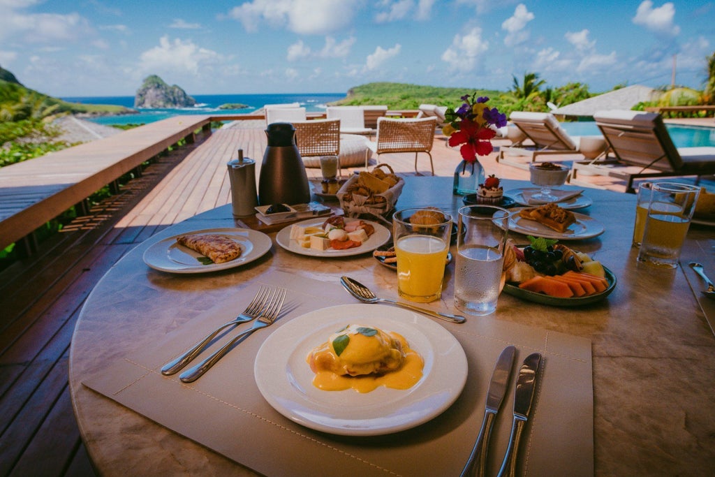 Luxury scenic beachfront resort with white minimalist architecture overlooking turquoise waters of Brazilian coastline at golden sunset hour