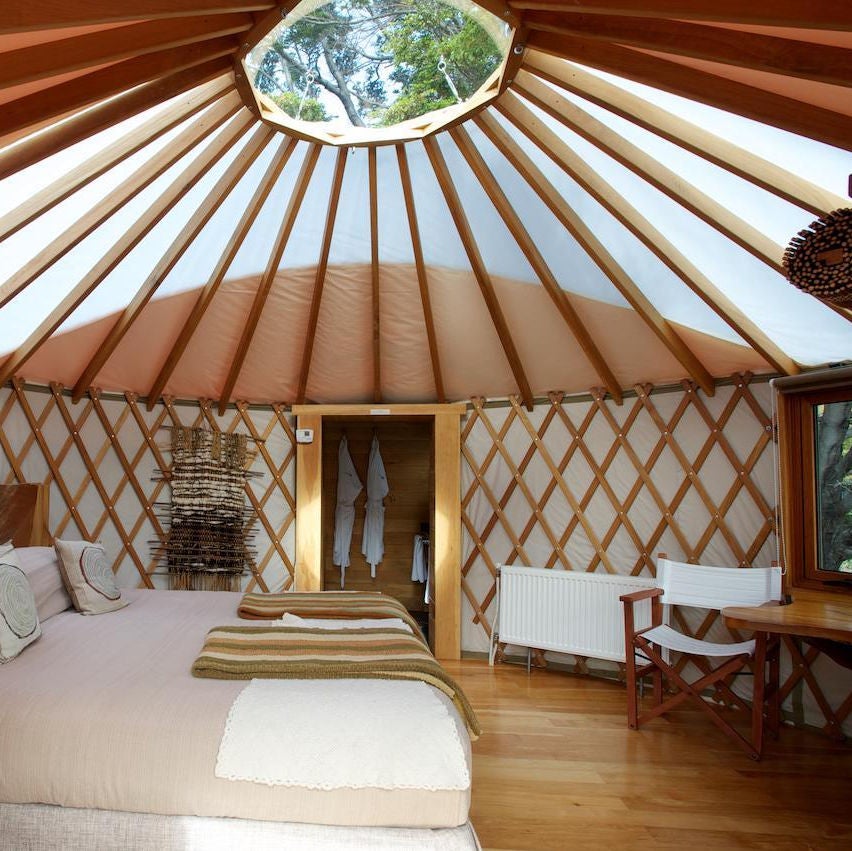 Luxury domed tents nestled in lush Patagonian forest overlooking snow-capped mountains and pristine lake with wooden deck walkways