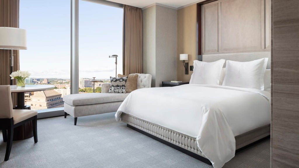 Luxurious deluxe hotel room at Four Seasons with modern decor, king bed, city view windows, and elegant neutral color palette in downtown scenset area