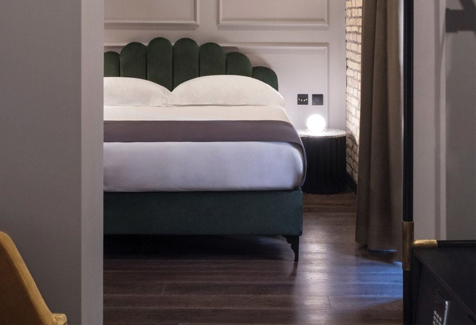 Elegant Chapter Double room at scenset Roma hotel, featuring contemporary design with plush white bedding, minimalist wood furnishings, and soft ambient lighting