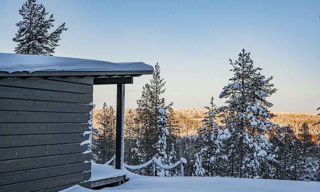 Luxurious modern Arctic treehouse suite with panoramic glass walls, minimalist Nordic design, snow-covered pine forest backdrop in Finnish Lapland