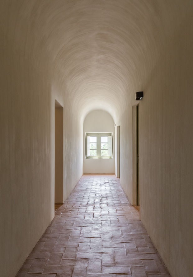 Rustic luxury hotel nestled among ancient olive trees at sunset, featuring whitewashed walls and traditional Portuguese architecture