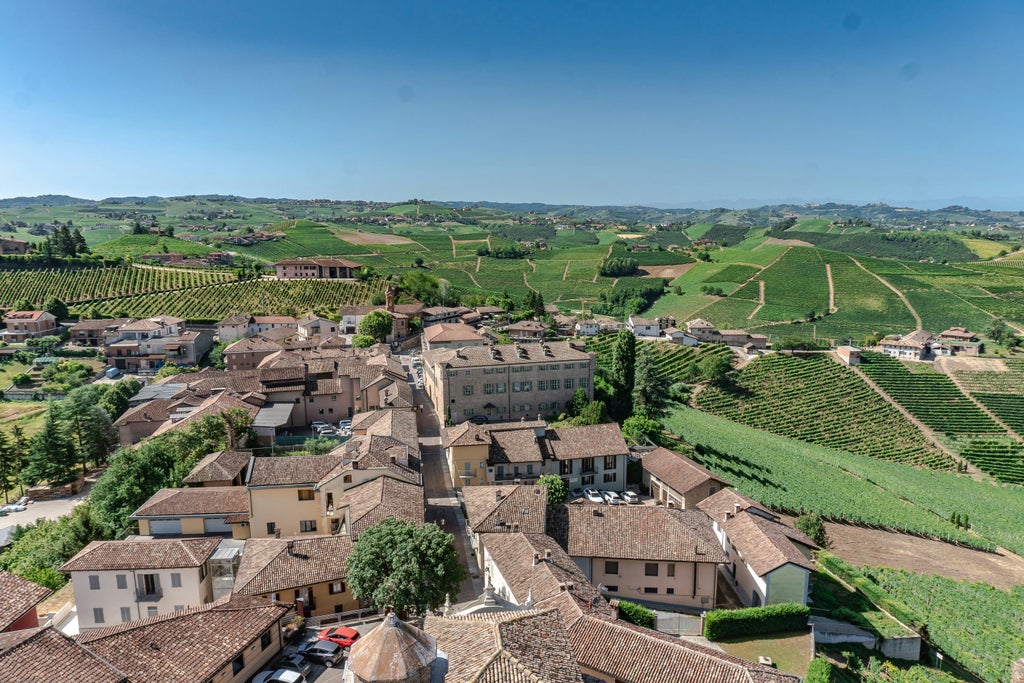 Rolling hills of Piedmont vineyards at sunset, with elegant villa estates and cypress trees dotting the golden-hued Langhe landscape