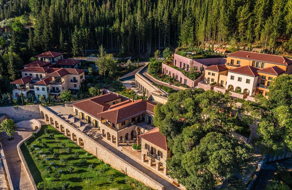 Serene infinity pool overlooking misty mountains at Euphoria Retreat, surrounded by lush greenery and traditional Greek architecture