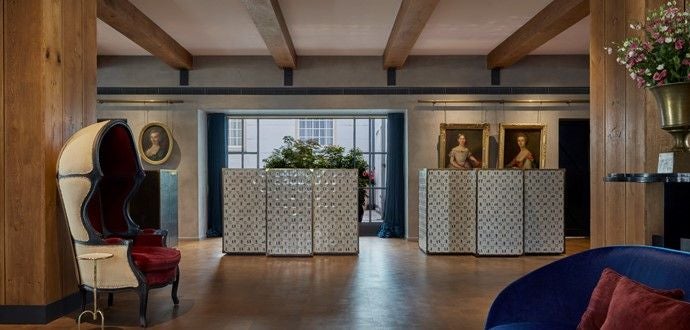 Historic canal-side Hotel Pulitzer Amsterdam with elegant brick facade, arched windows and flowering window boxes along Amsterdam's waterways