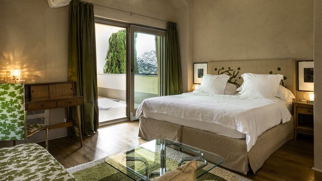 Elegant Tuscan hotel room with panoramic windows overlooking rolling hills, minimalist design, crisp white linens, and warm natural light streaming in