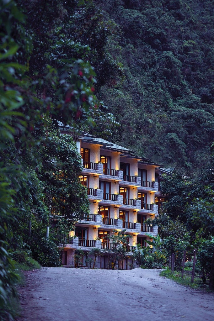 Luxurious SUMAQ hotel nestled at the base of Machu Picchu mountain, featuring elegant stone and glass architecture amid lush Andean jungle