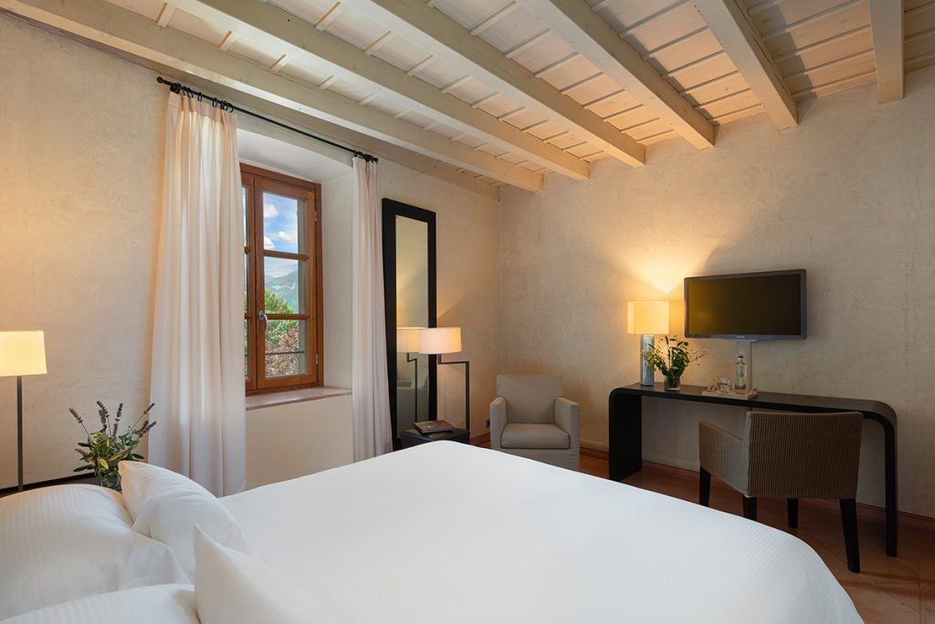 Luxurious deluxe hotel room at Hotel Salò Villa Arcadio, featuring elegant Italian decor, lake view, plush bedding, and sophisticated architectural details