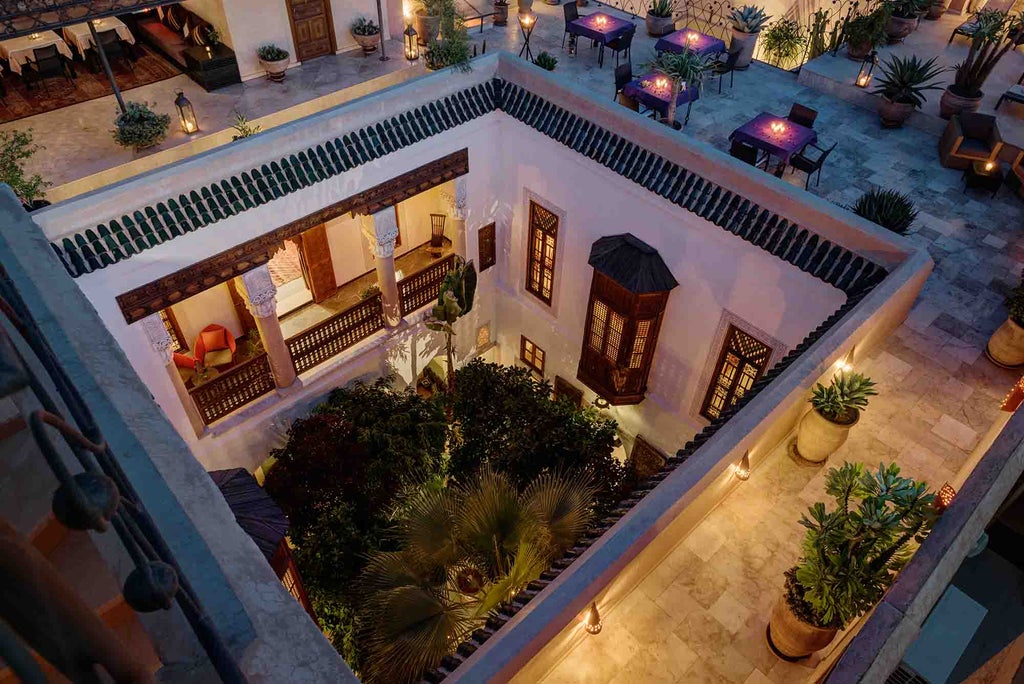 Elegant Moroccan courtyard with ornate archways, plush seating, and traditional lanterns surrounding a tranquil fountain in Riad Siwan