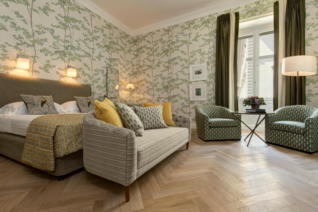 Elegant classical Italian hotel facade with ornate stone balconies, tall arched windows, and traditional Tuscan architectural details in Florence