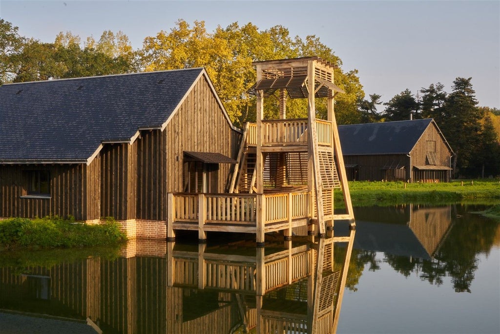 Luxurious wooden-paneled hotel room with elegant four-poster bed, soft neutral tones, and refined French countryside charm at Les Sources de Cheverny