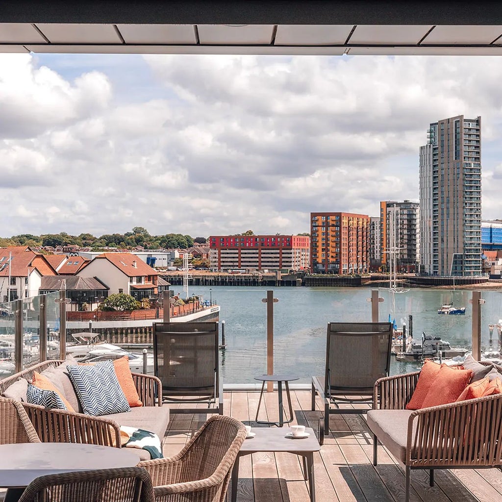 Luxurious deluxe marina view suite at Scenset Harbour Hotel Southampton, featuring elegant decor, spacious balcony overlooking waterfront, contemporary design