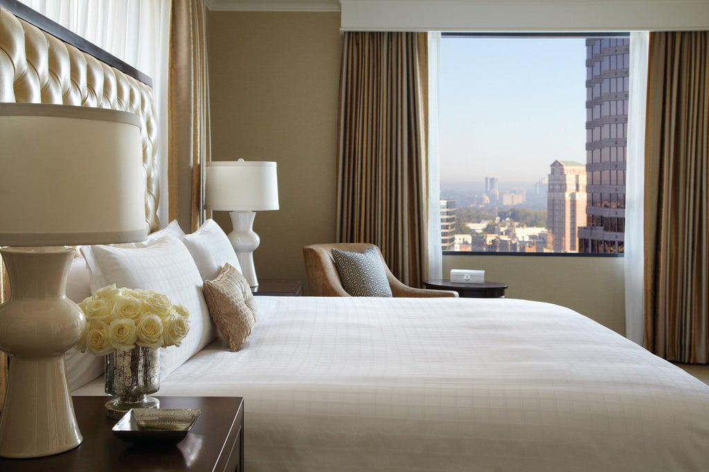 Elegant high-rise Four Seasons Hotel in Atlanta with glass facade, modern architecture, and landscaped entrance under sunny blue skies