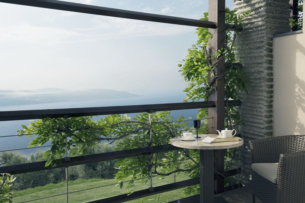 Luxurious infinity pool overlooking Lake Garda and mountains, with elegant loungers and natural stone features at sunset