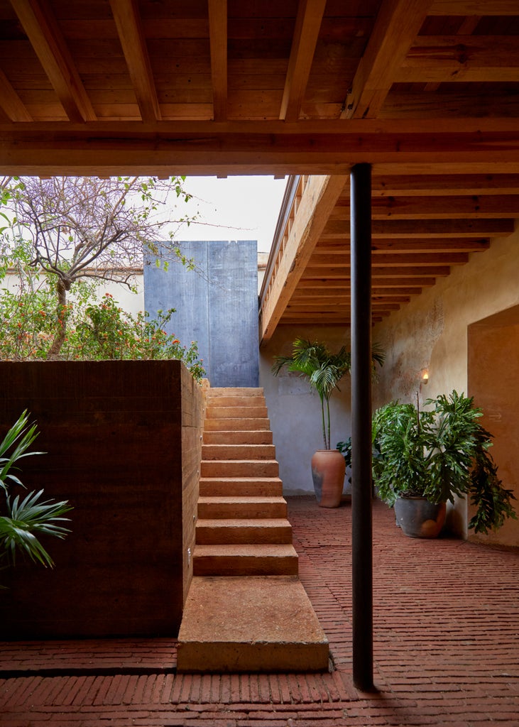 Luxurious boutique hotel nestled in lush Oaxacan landscape, with minimalist white architecture, verdant tropical plants, and serene outdoor lounging area