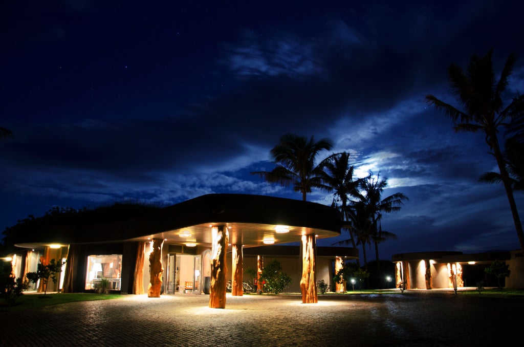 Luxurious Nayara Hangaroa hotel nestled on Easter Island's coast, featuring curved stone architecture and panoramic Pacific Ocean views