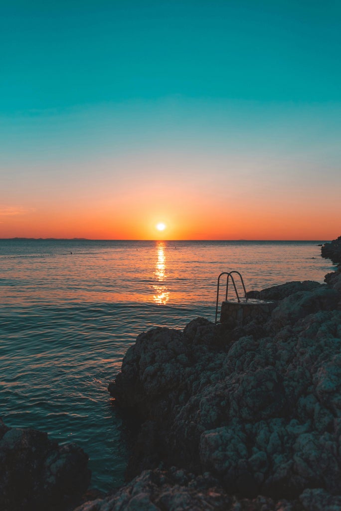 Postcard-worthy view of Zadar's Venetian Old Town at sunset, featuring marble-paved promenade and famous sea organ along turquoise Adriatic Sea