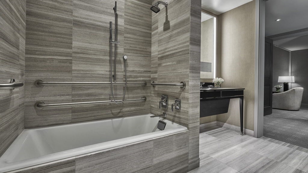 Spacious Four Seasons Executive Accessible Suite with modern decor, plush king bed, sleek marble bathroom, and stunning city skyline view in Boston