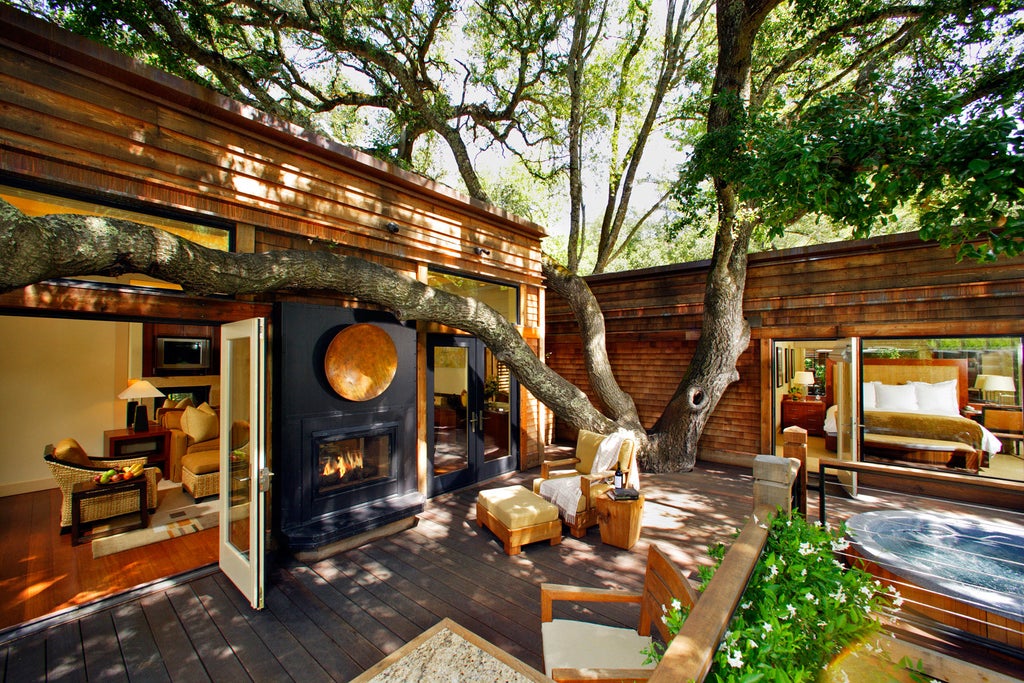 Luxurious woodland resort with private timber lodges nestled among oak trees, featuring elegant outdoor terraces and natural stone