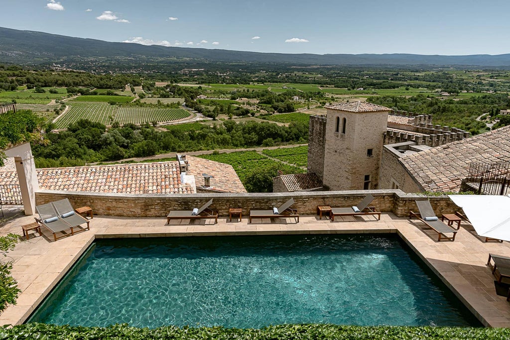 Stone-built luxury hotel in Provence with terracotta roofs, featuring a terraced pool overlooking rolling French countryside and Mont Ventoux