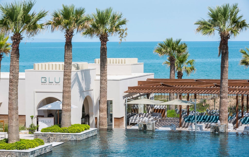 Elegant beachfront Four Seasons hotel in Tunisia with white Mediterranean architecture, palm trees, and turquoise infinity pools