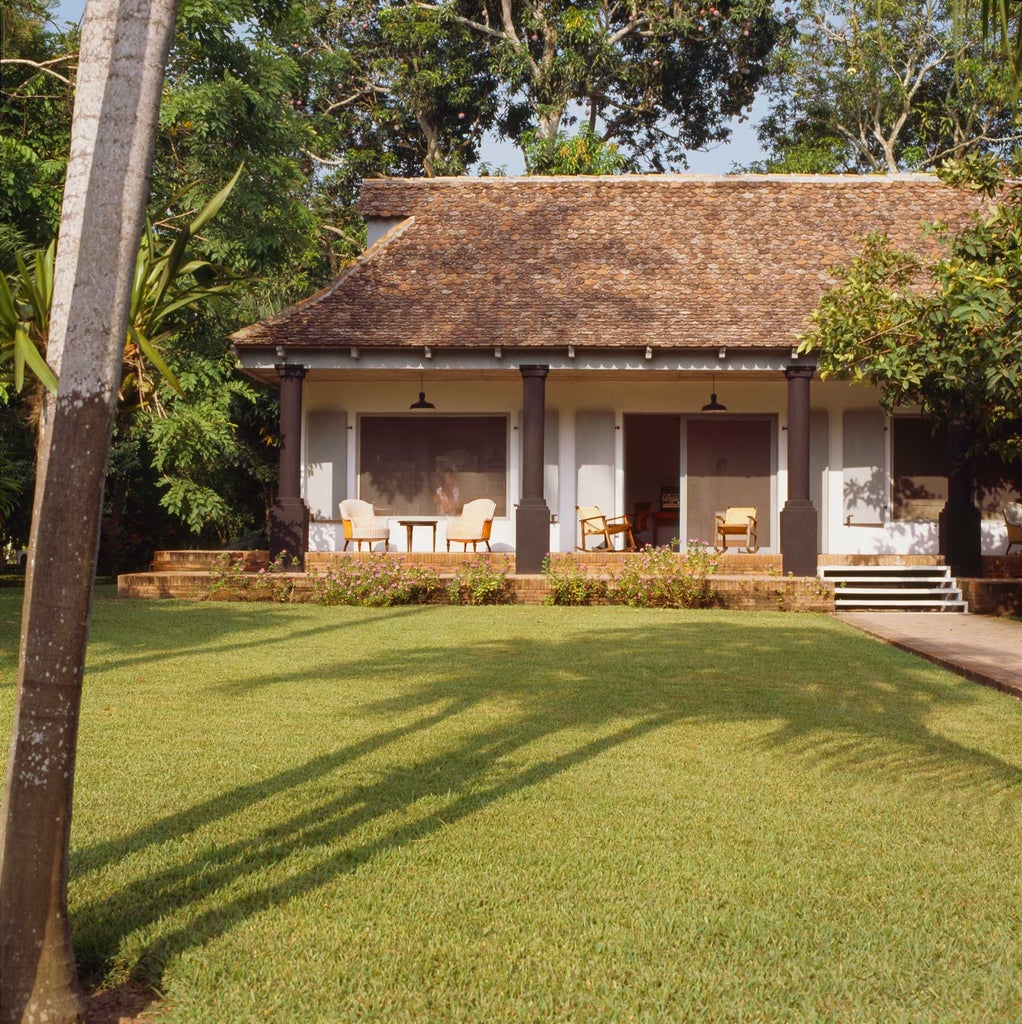 Elegant colonial-style boutique hotel with vibrant pink exterior, lush tropical gardens, and traditional Mexican architectural details nestled in scenic landscape