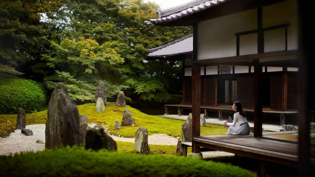 Elegant luxury hotel overlooking the Kamo River with traditional Japanese architecture, sunset reflecting on windows and zen garden landscaping