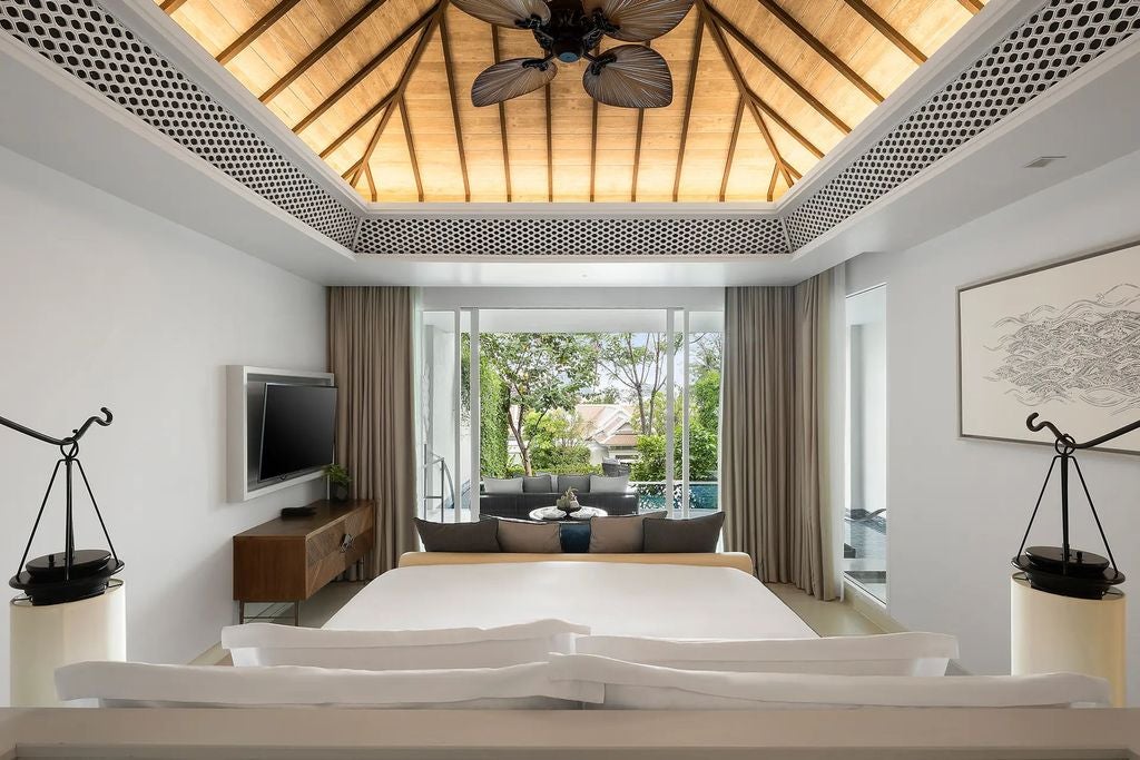 Modern luxury suite with private infinity pool overlooking tropical Andaman sea, featuring king bed and wellness-focused living space