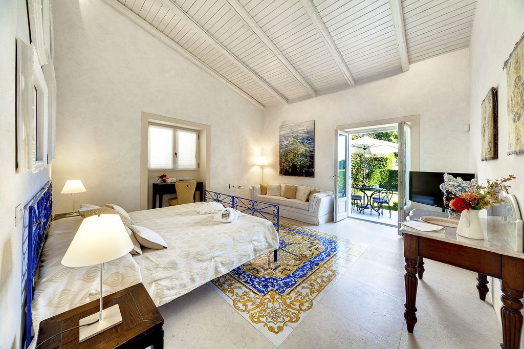 Elegant Sicilian hotel room with refined white linens, antique wooden furniture, and soft natural light filtering through delicate curtains